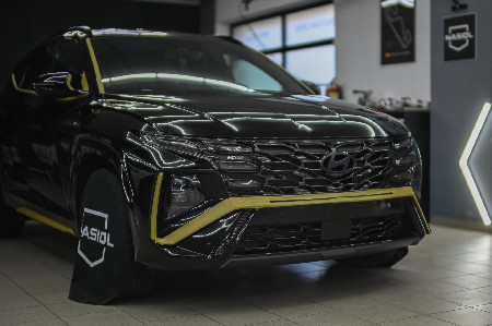 Hyundai Tucson N Line s maskovací páskou během přípravy a leštění laku.